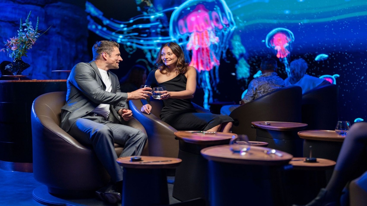 Couple enjoying drinks at Europa-Park's Eatrenalin with glowing jellyfish projections on the walls.