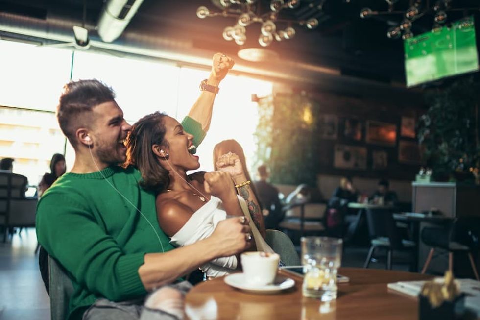 Couple looking happy after their football team score thanks to Listen EVERYWHERE