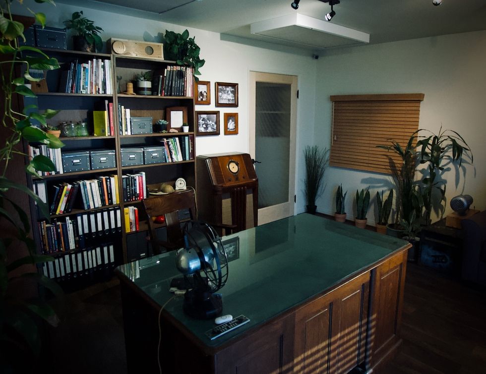 Cozy office at SSI Inc. with plants, bookshelf, desk, and vintage decor.