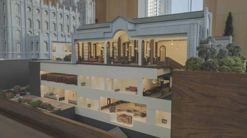 Cross-section model of a multi-story temple building with detailed interiors and greenery.