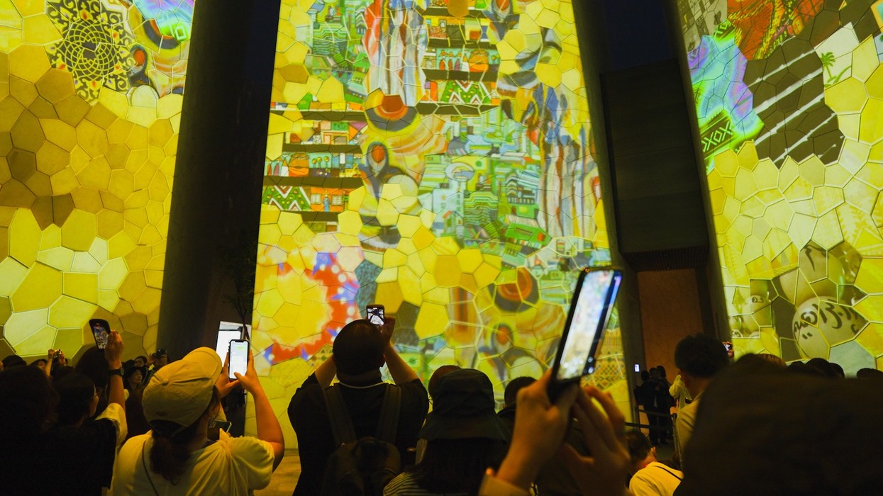Crowd capturing vibrant projections on mosaic-patterned walls with phones, KSA pavilion Expo 2025 Osaka
