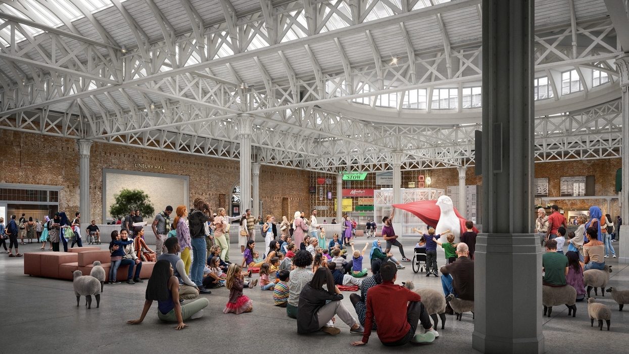 Crowd gathered in a spacious hall at the London Museum with a high ceiling, watching a large pelican sculpture.