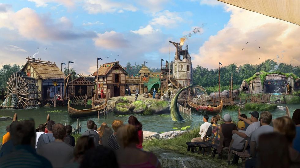 Crowd watching medieval village scene with boats and a water dragon at Kynren theme park