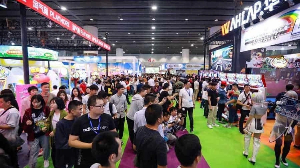 Crowded AAA expo with colorful booths and attendees exploring displays.