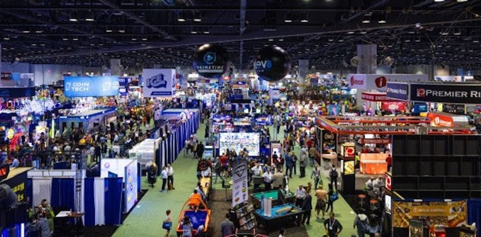 Crowded convention center filled with diverse exhibition booths and attendees.