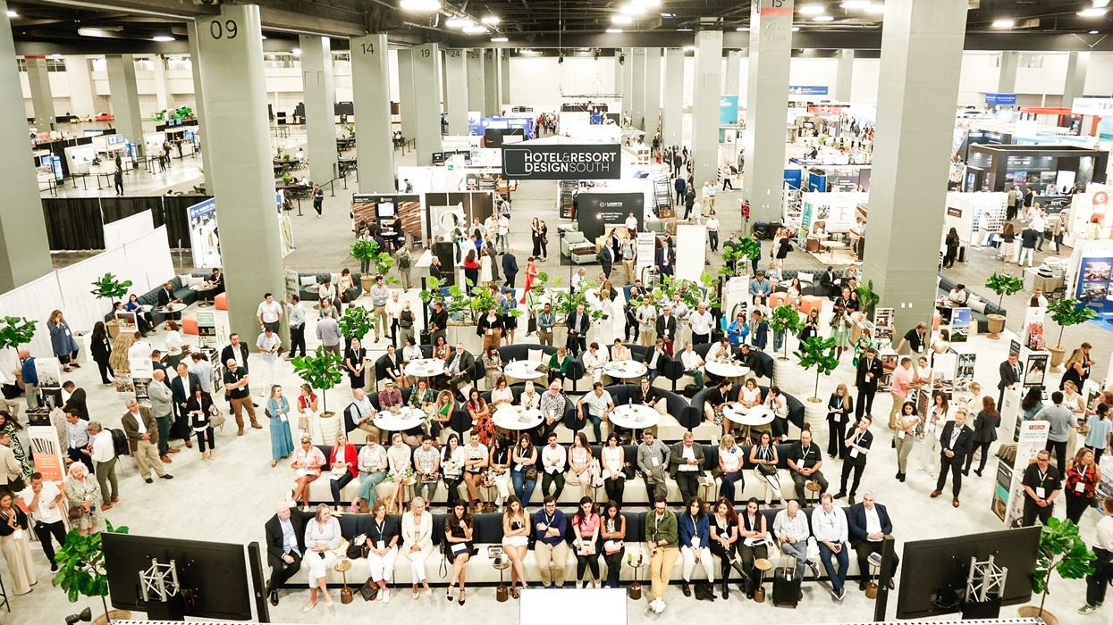 Crowded design expo with seated audience, booths, and numerous attendees in a large hall.