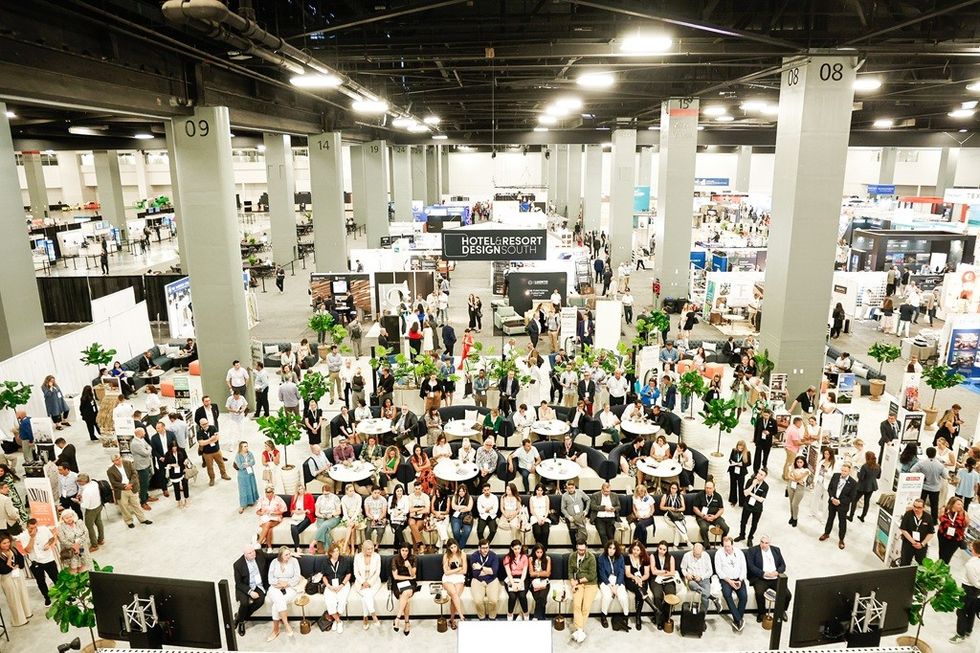 Crowded exhibition hall with attendees seated and standing at the Hotel & Resort Design Show.