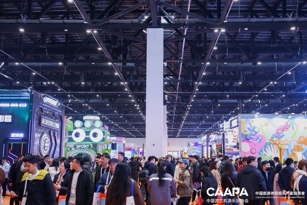 Crowded exhibition hall with vibrant displays and attendees.
