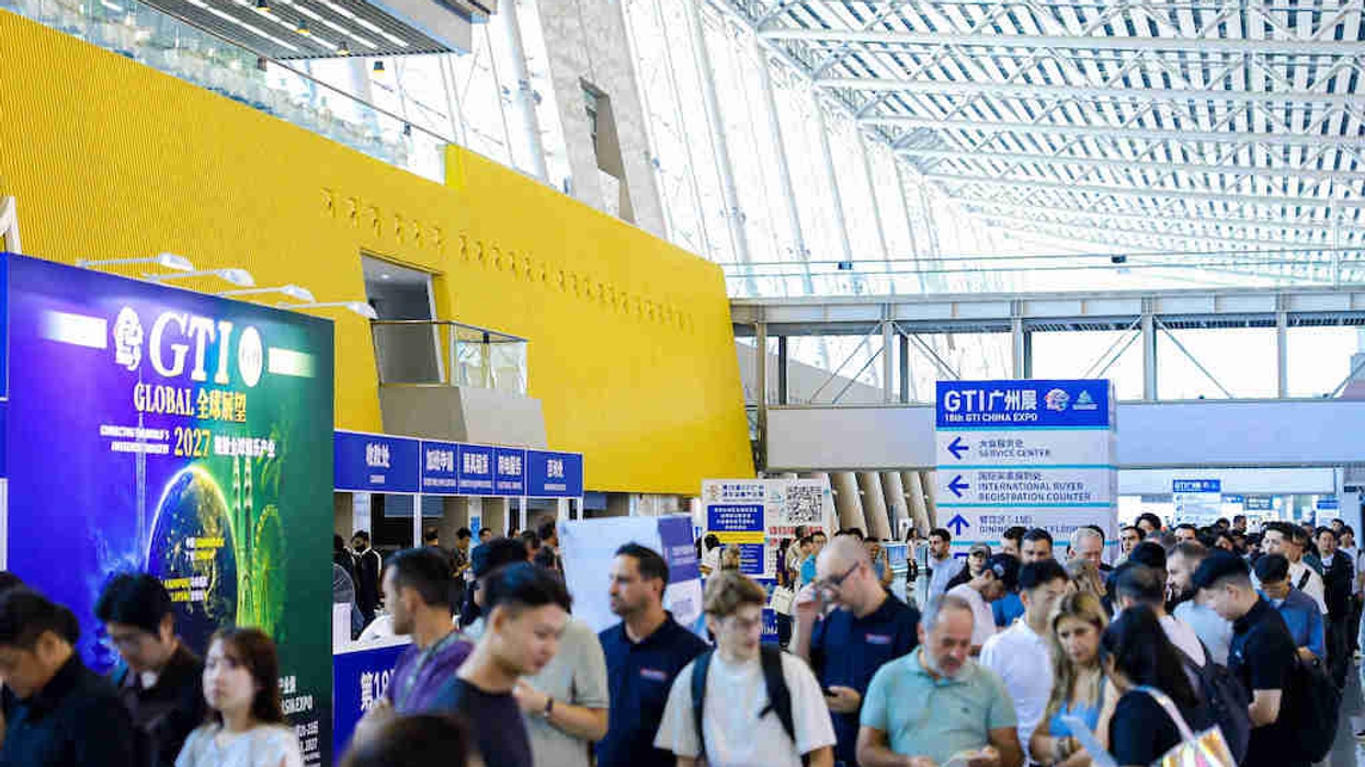 Crowded expo hall with people at the GTI Global event in a modern building.