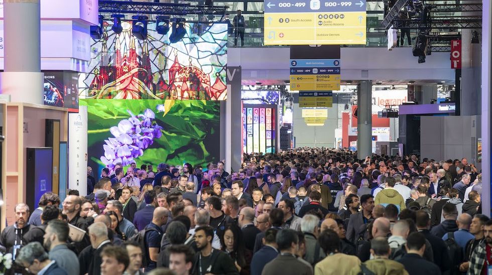 Crowded tech expo with people and digital displays.