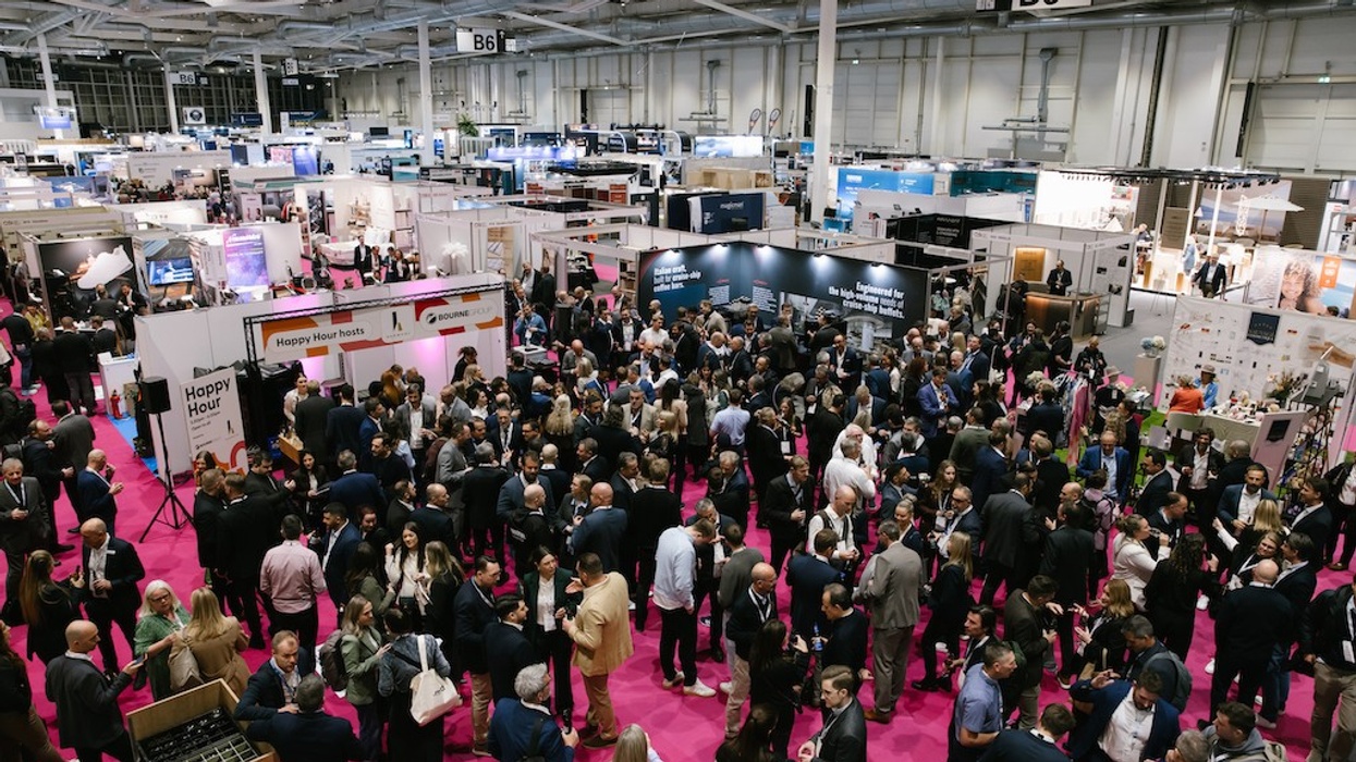 Crowded trade show with attendees networking in a large, brightly lit convention center.