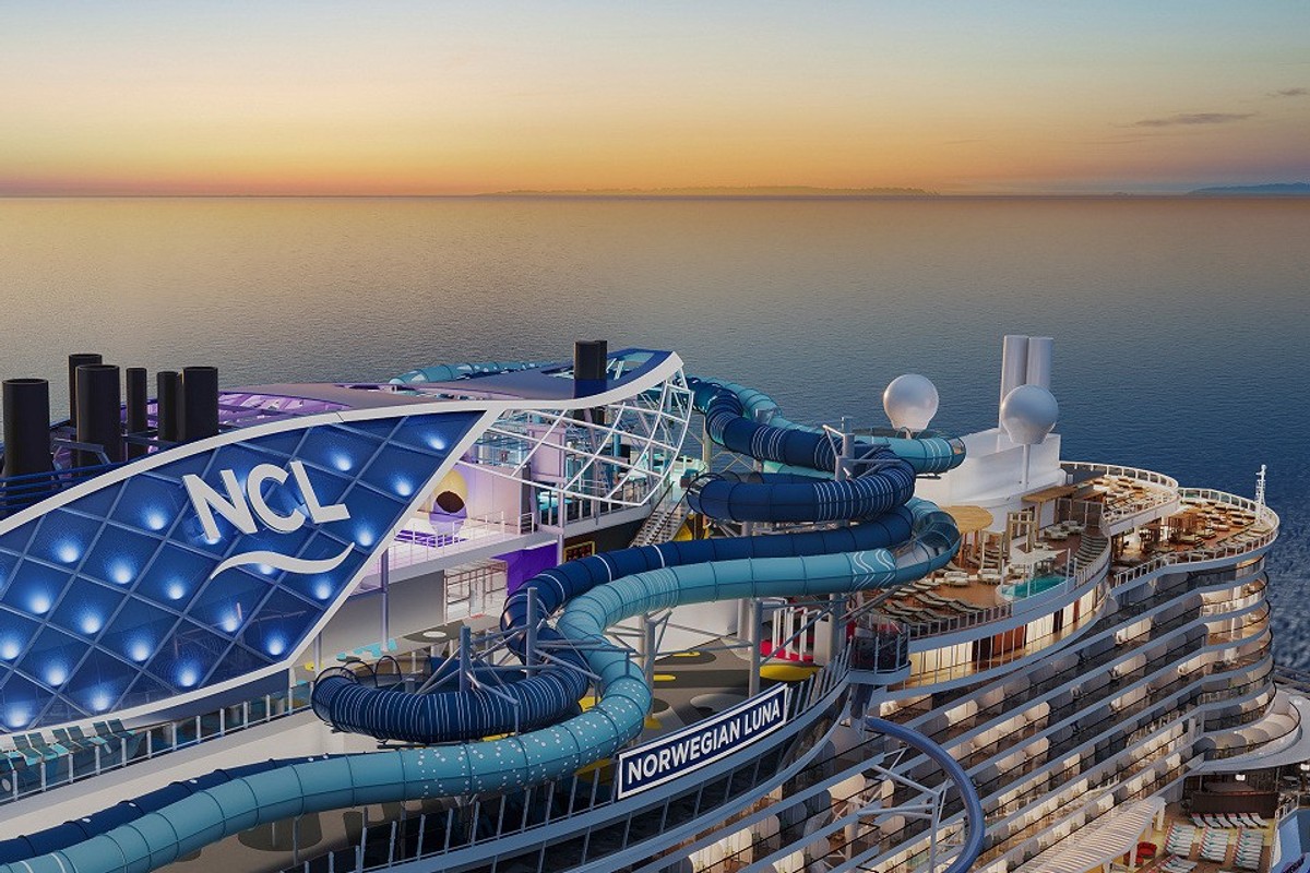 Cruise ship deck at sunset with waterslides and "NCL" signage.