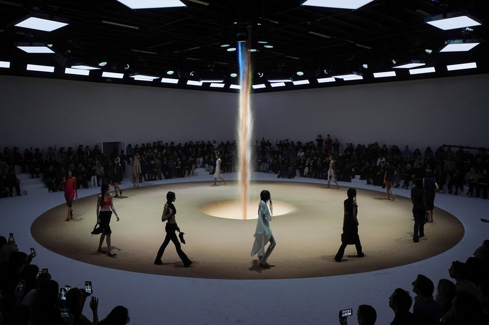 Crystal. Fashion show models walk around an illuminated waterfall installation on a circular runway.