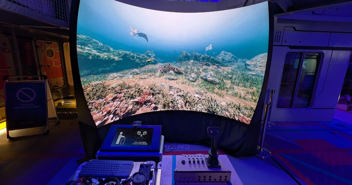 Curved screen displaying underwater scene with diving equipment controls in front.
