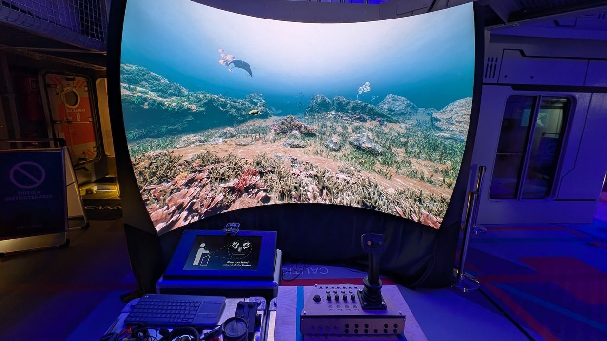 Curved screen displaying underwater scene with diving equipment controls in front.