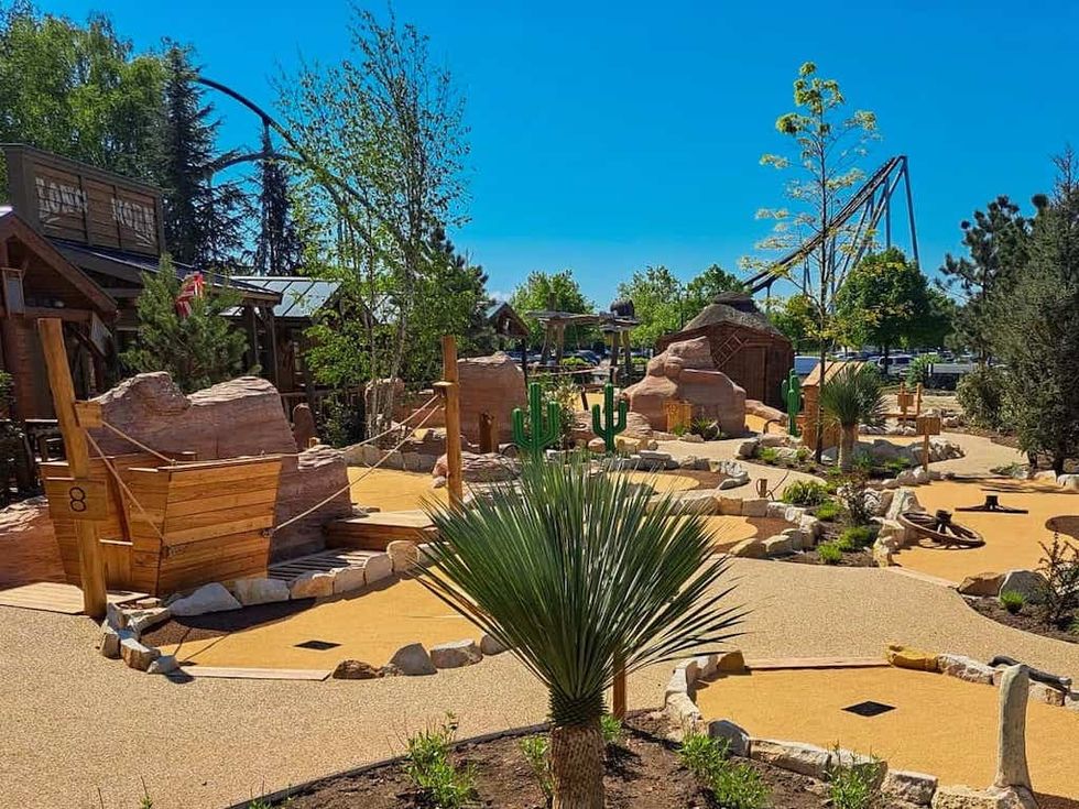 Desert-themed mini-golf course with wooden structures and artificial cacti.