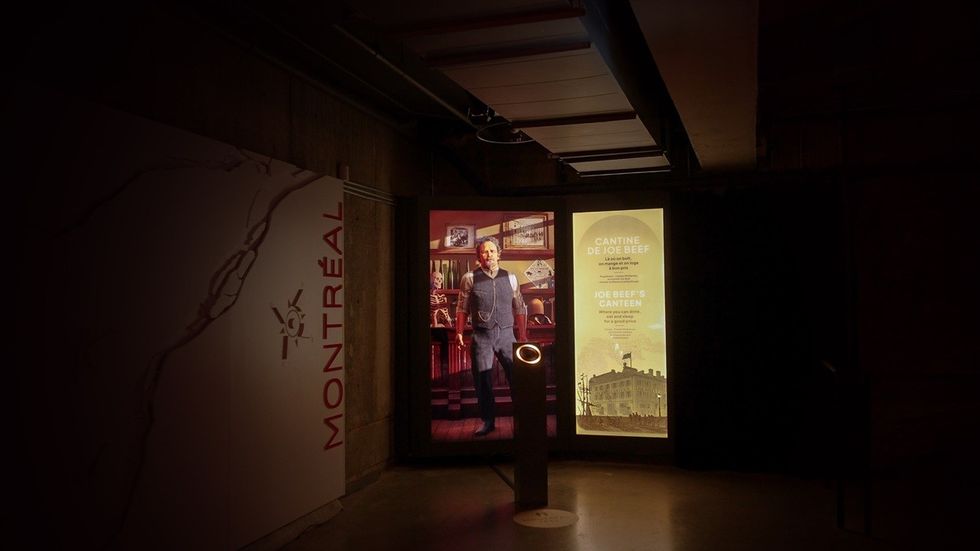 Dimly lit exhibition with a Monteal sign and a Joe Beef's Canteen display.