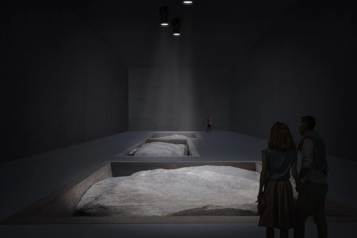 Dimly lit gallery with rock displays and three people observing at Museu Bernardo Paz