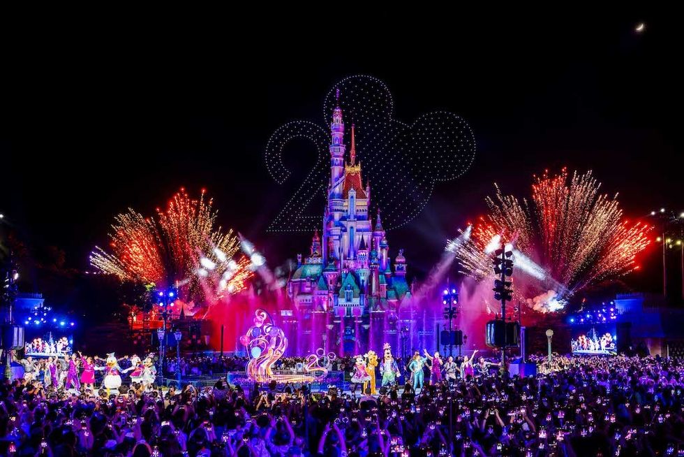 Disney castle fireworks show with characters at Hong Kong Disneyland, celebrating an anniversary at night.
