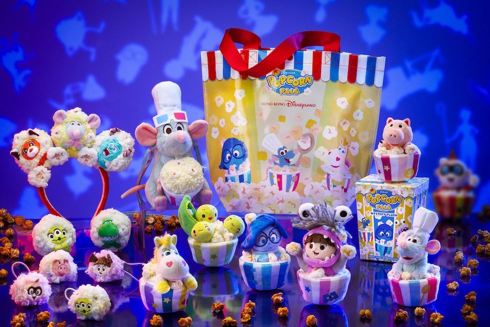 Disney-themed plush toys and accessories with a popcorn theme on a colorful background.