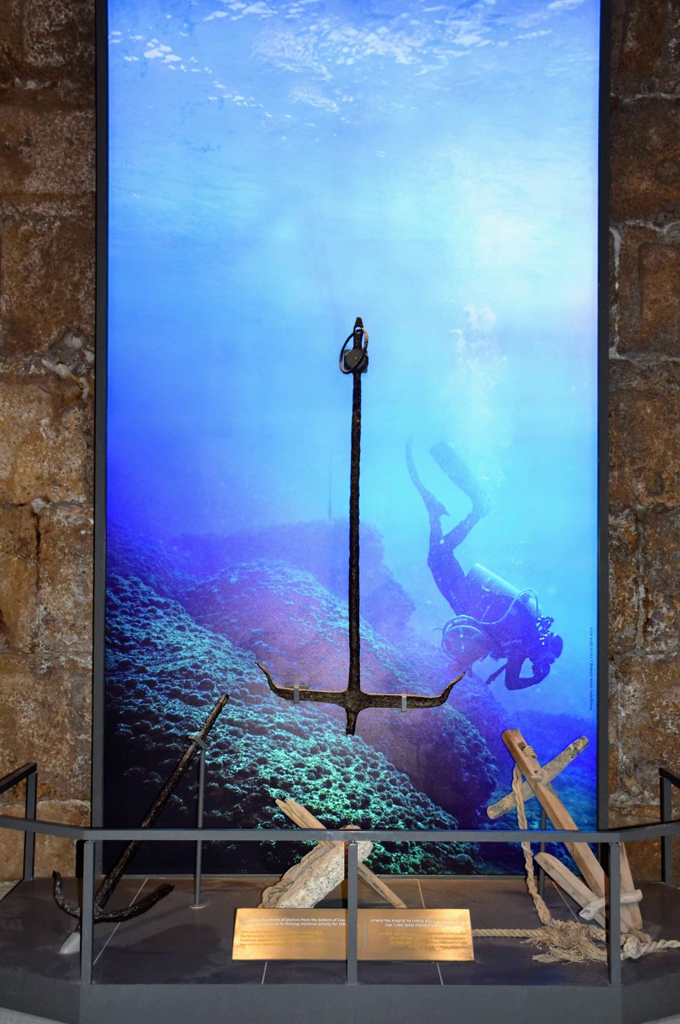 Display of ancient anchors with diver backdrop in an underwater-themed exhibit at Caesarea Harbour Visitor Centre