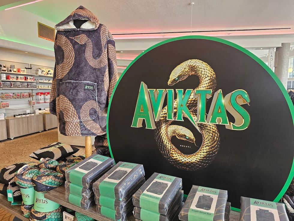 Display of "Aviktas" merchandise, featuring snake-themed apparel and packaged items.