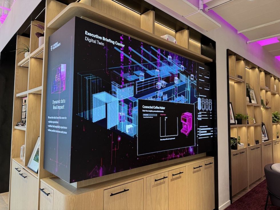 Display of digital twin technology and connected coffee maker in modern briefing center.