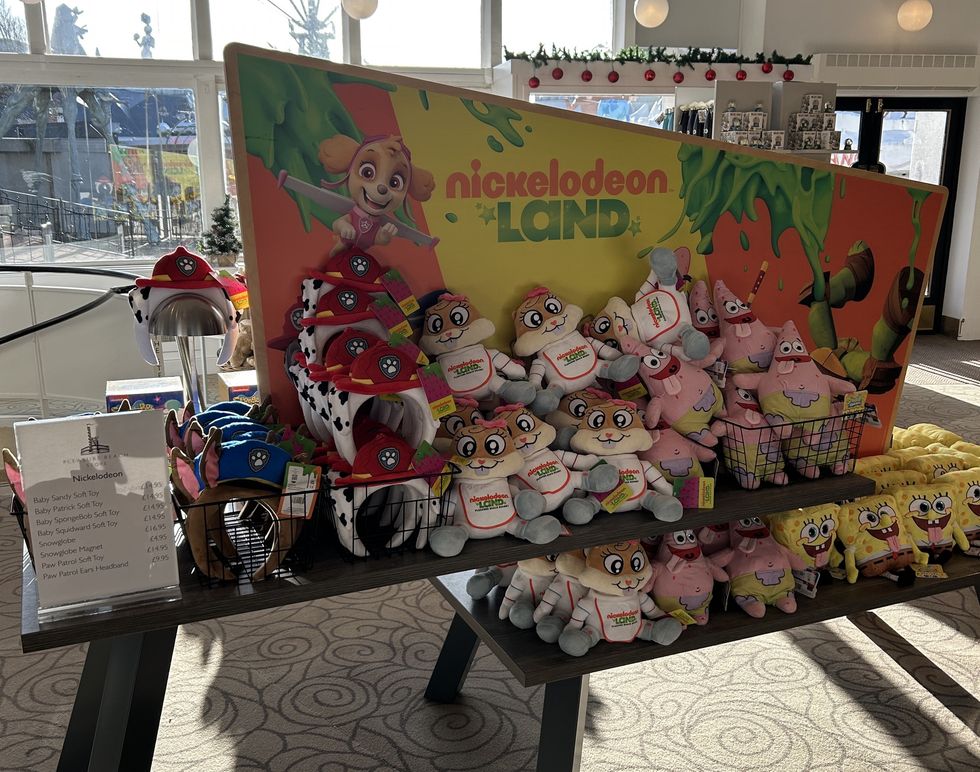 Display of Nickelodeon plush toys and hats at a themed merchandise stall.
