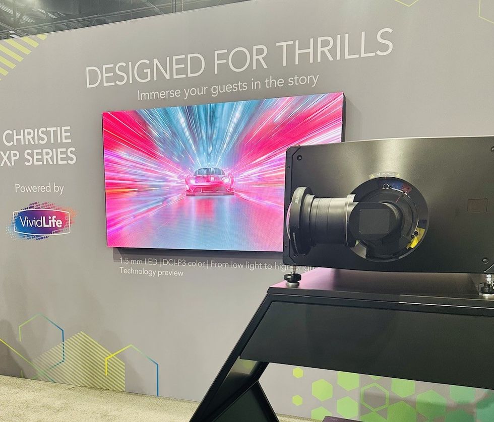 Display with a vibrant racing car image and projector setup, showcasing "Designed for Thrills."