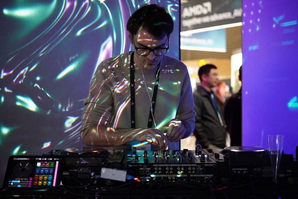 DJ performing with colorful lights projected on him.
