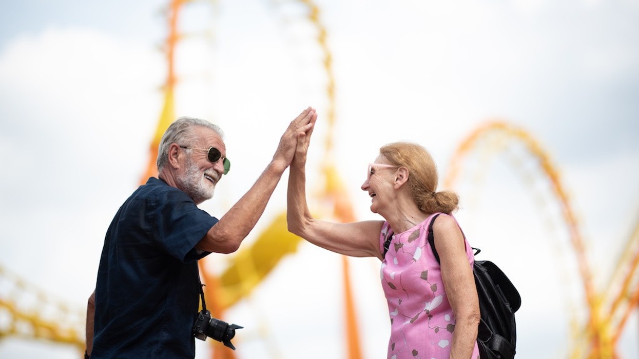 elderly senior couple woman and man having fun and happy together at amusement them park retirees