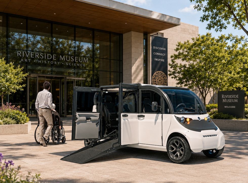 Electric vehicle with wheelchair ramp outside Riverside Museum entrance.