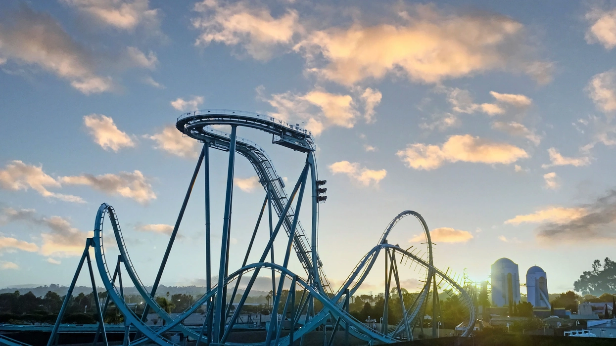 Emperor rollercoaster track under a sky with scattered clouds at sunset at SeaWorld San Diego