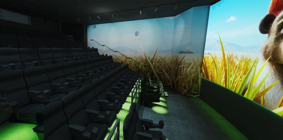 Empty 4D movie theater with side and front screen, showing a grassy landscape scene.