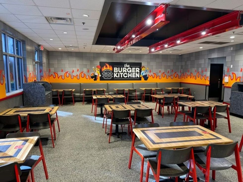 Empty The Burger Kitchen at LEGOLAND with red chairs and flame-themed wall decor.