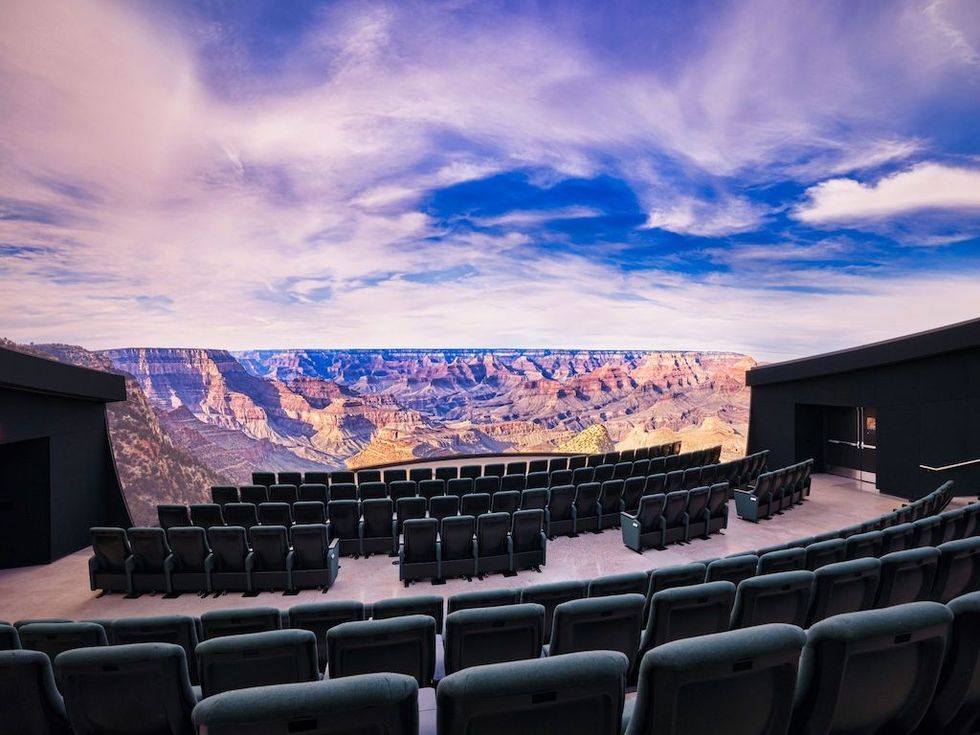 Empty theater with Grand Canyon view and vibrant sky backdrop.