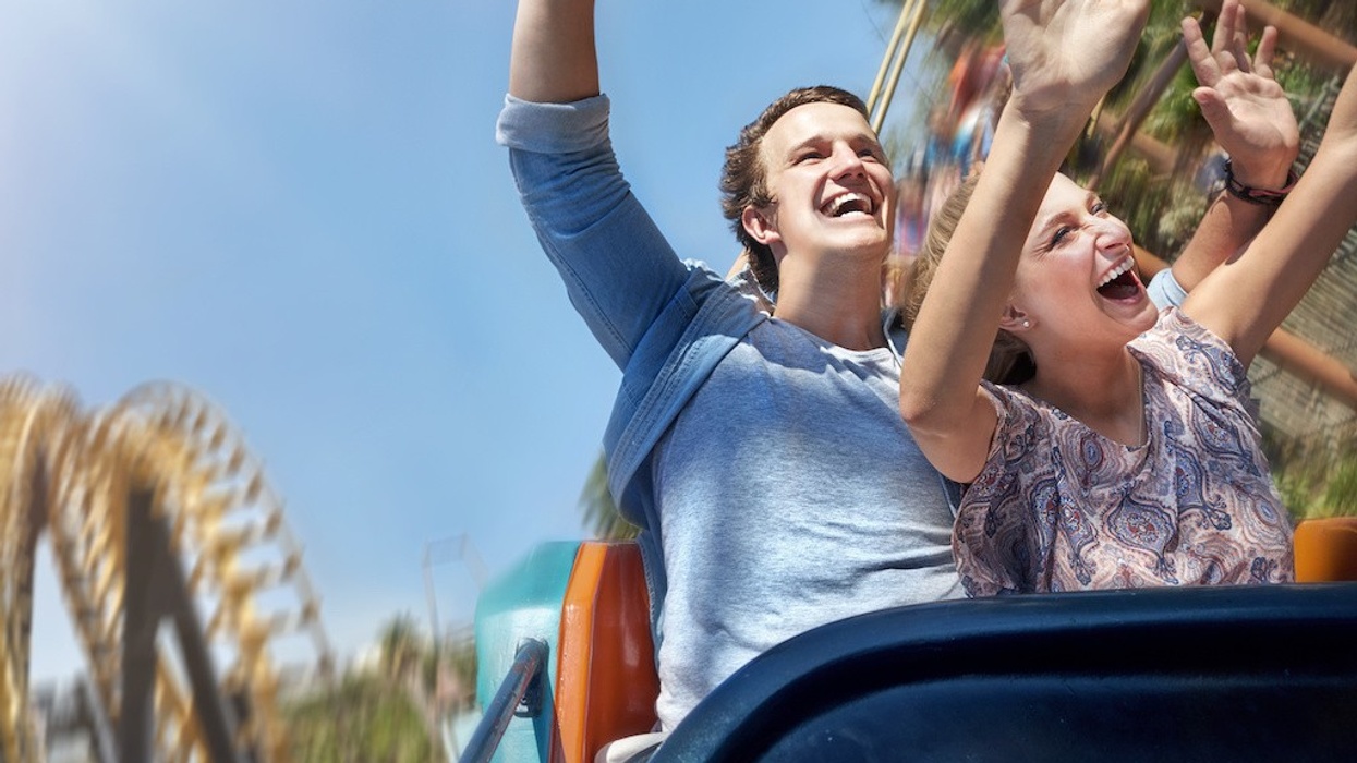 Enthusiastic couple cheering and riding amusement park ride