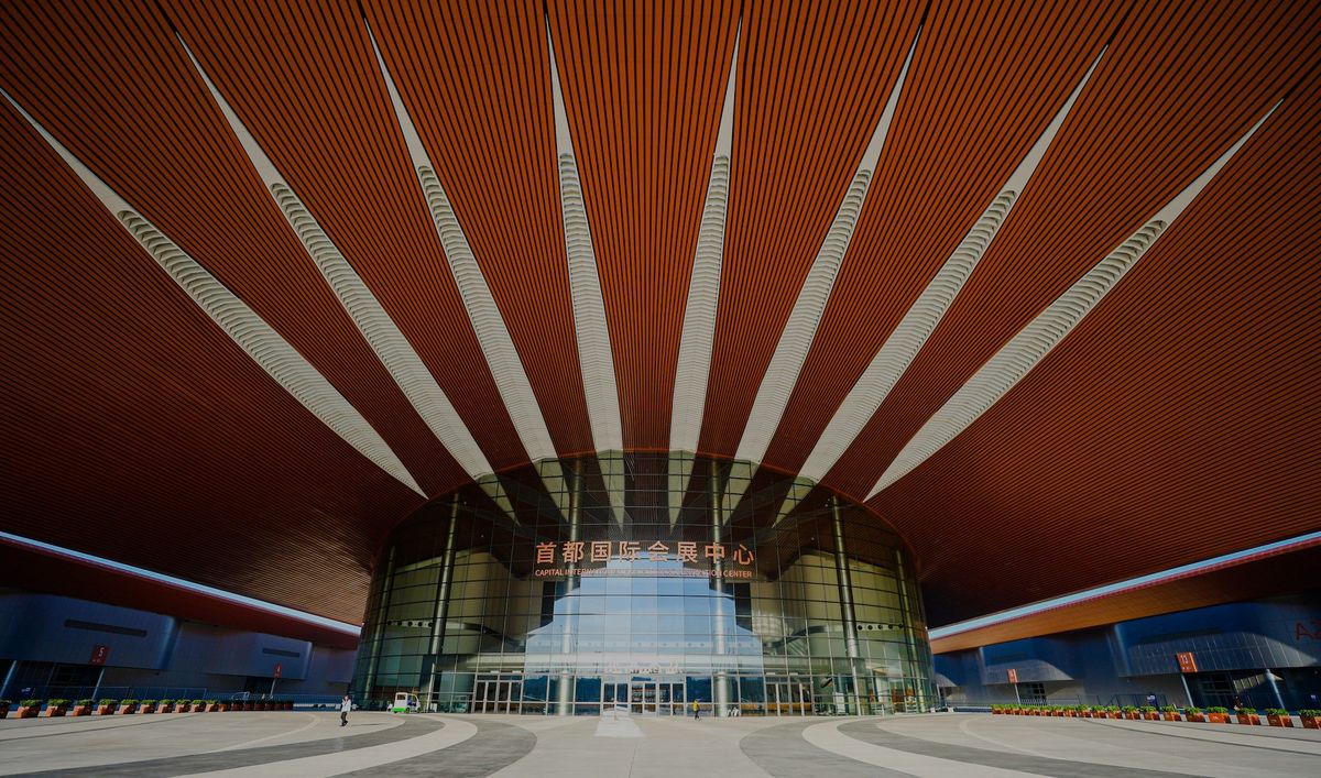 Entrance of a modern building with sunbeam-like ceiling design.