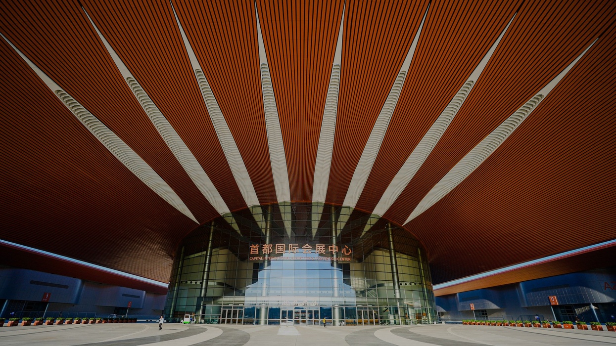 Entrance of a modern building with sunbeam-like ceiling design.