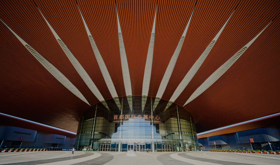 Entrance of a modern building with sunbeam-like ceiling design.