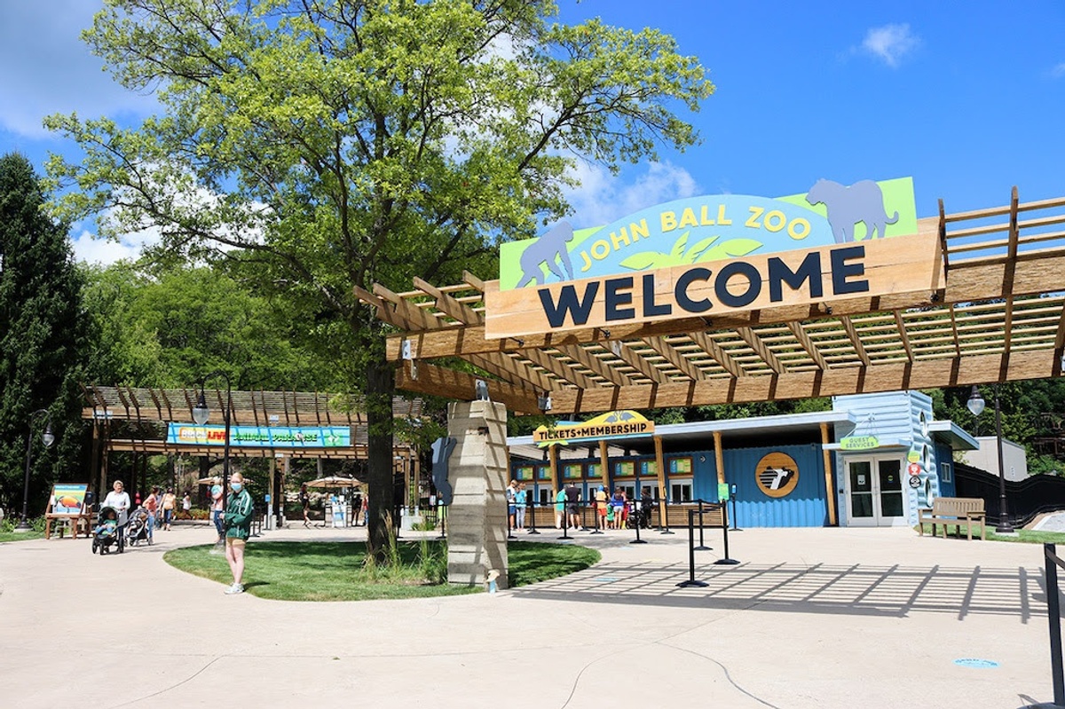Entrance of John Ball Zoo with welcome sign and ticket booths.
