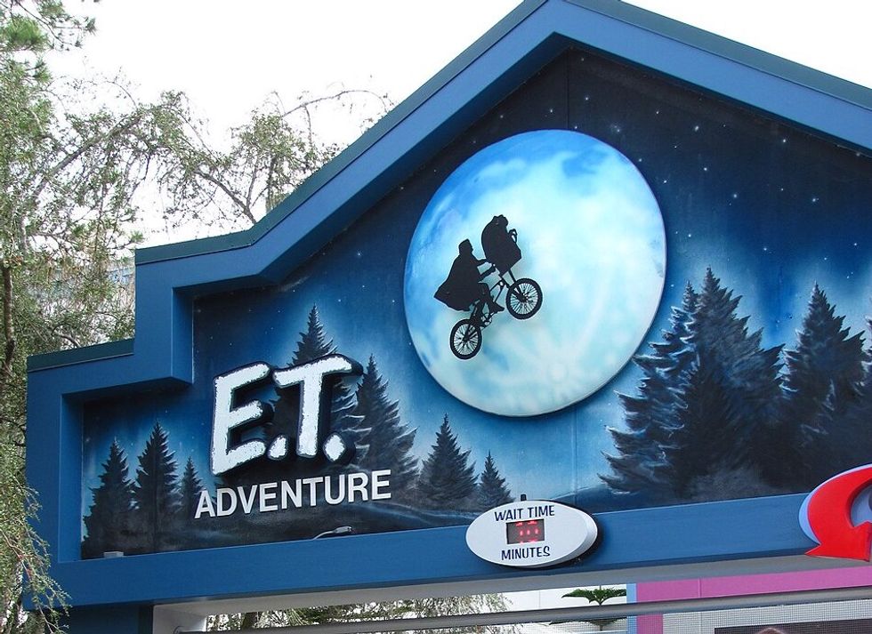 Entrance sign for the "E.T. Adventure" ride featuring a bicycle silhouette over the moon.