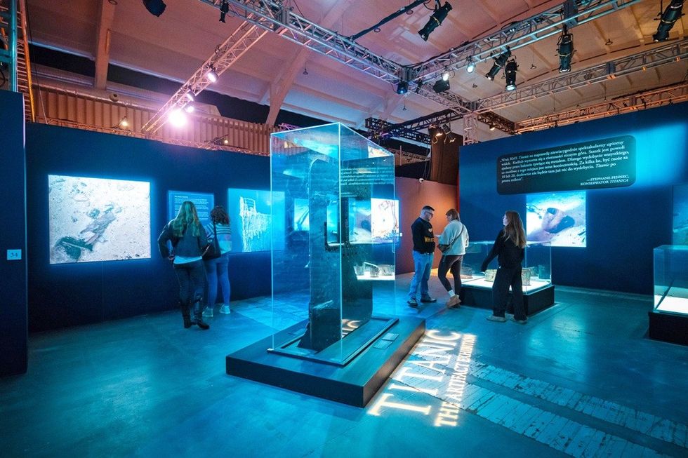 Exhibit of Titanic artifacts with illuminated display cases and informational panels.