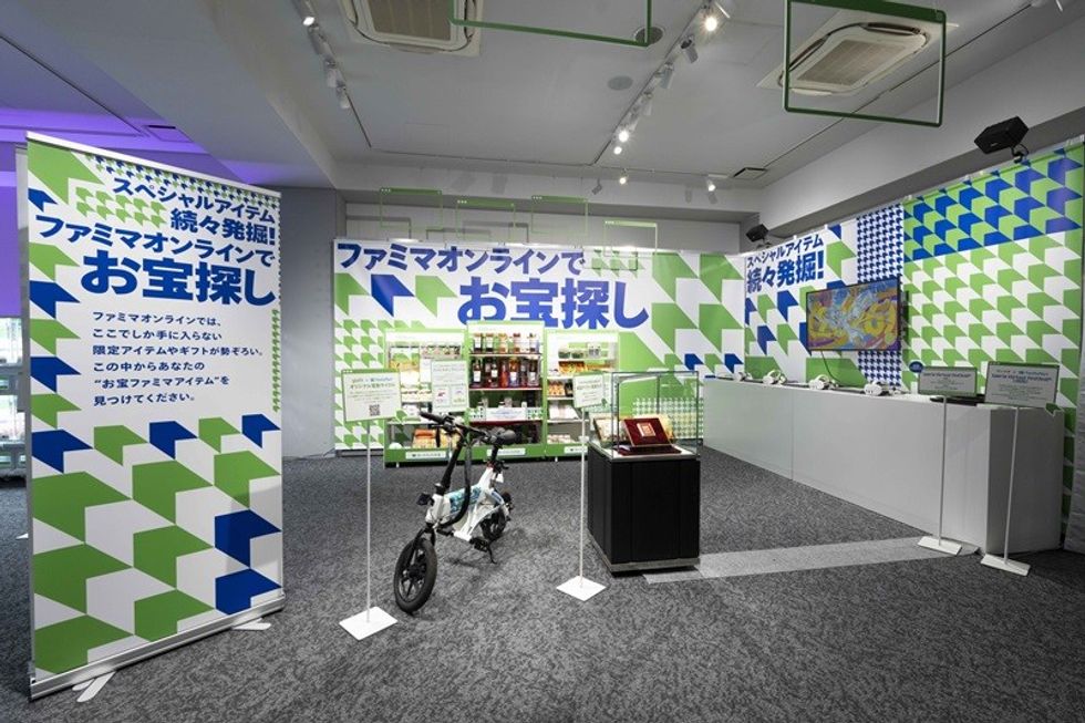 Exhibit room with colorful geometric patterns, promotional banners, and a display bicycle.