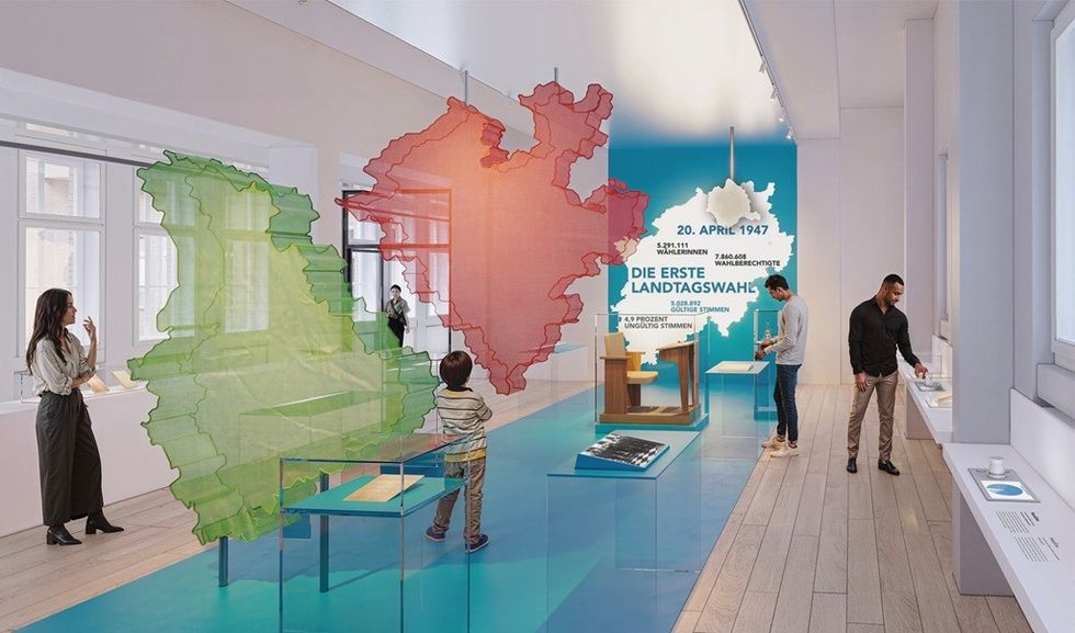 Exhibit with colorful map outlines and visitors in a modern museum.