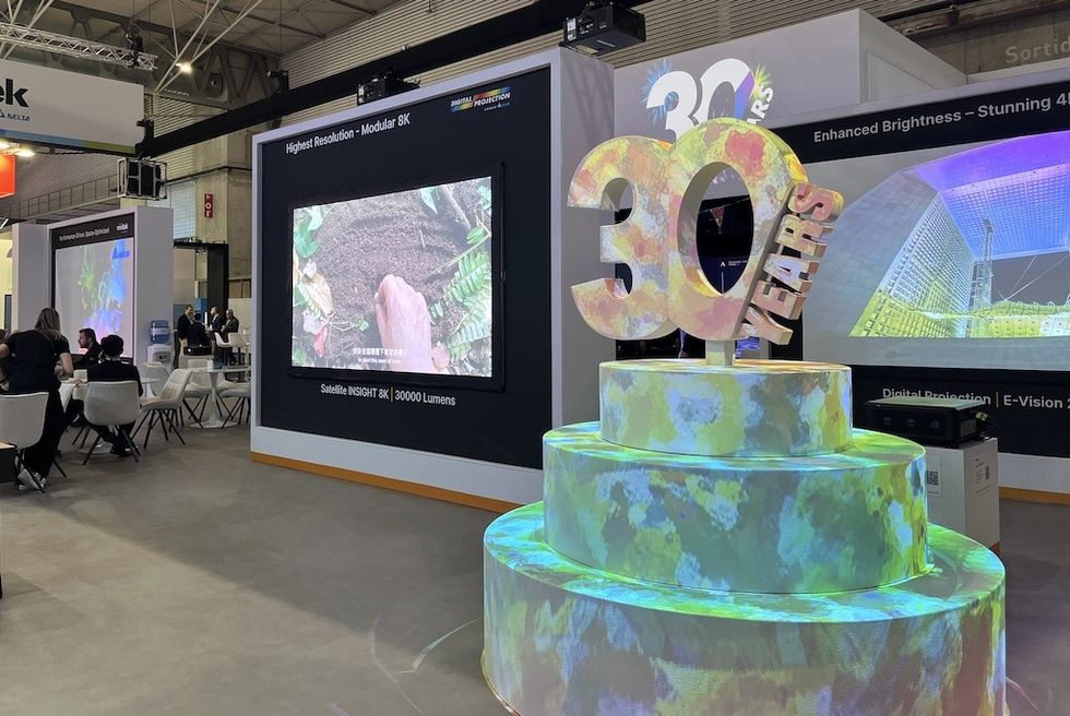 Exhibition booth with "30 Years" display and large screen showing 8K video.