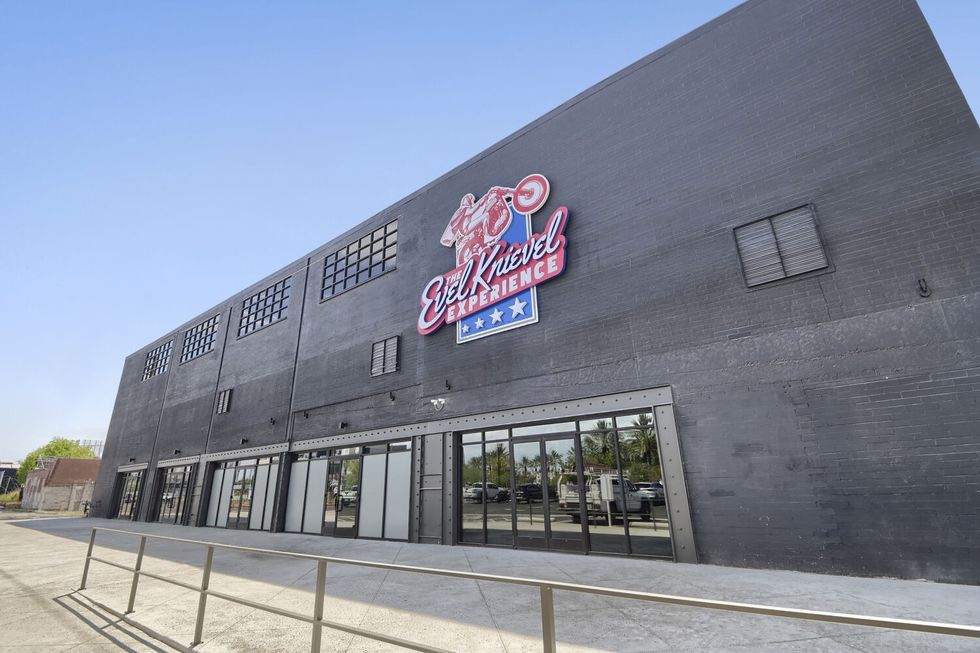 Exterior of a gray building with "Evel Knievel Experience" sign on it.