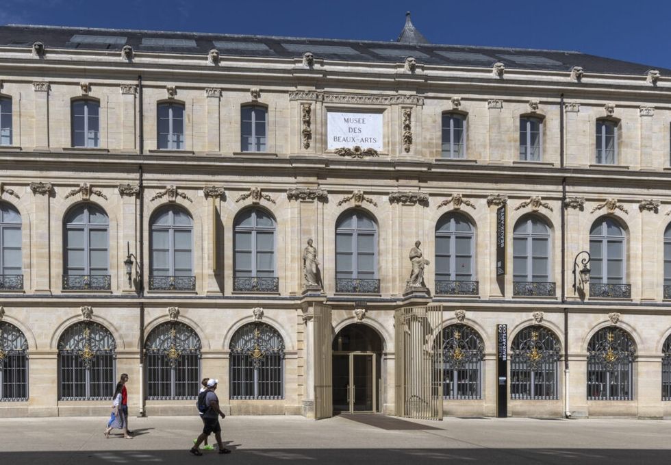 Exterior of Mus\u00e9e des Beaux-Arts with pedestrians and classical sculptures.