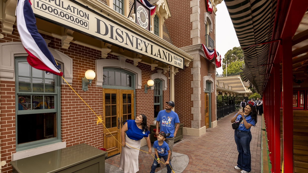 Family at Disneyland celebrates population milestone with flag decorations.
