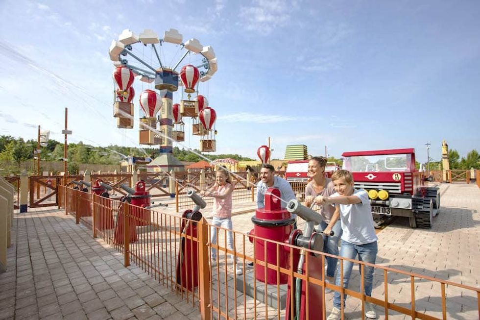Family at Legoland Deutschland with firetruck themed water cannons and balloon ride.